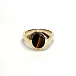 The City of London Jewellers presents the Eyemouth heavy 9ct yellow gold 12mm x 10mm oval Tigers Eye with a slightly curved top rub-over set into a plain polished signet ring, angled view laying down from the front.