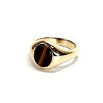 The City of London Jewellers presents the Eyemouth heavy 9ct yellow gold 12mm x 10mm oval Tigers Eye with a slightly curved top rub-over set into a plain polished signet ring, angled view laying down from the front facing left.