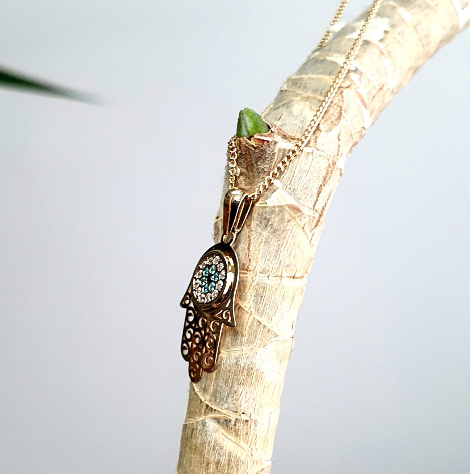 9ct yellow gold filigree style evil eye hamsa pendant and chain/necklace pendant height, including saddle bail 23.6mm width 12.5mm evil-eye set with a single black CZ pupil surrounded with six blue CZs and twelve white CZs.