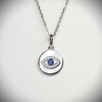 A round disc silver evil eye necklace/pendant made in real sterling silver with sparkling blue & white cubic zirconia with a highly polished finish.