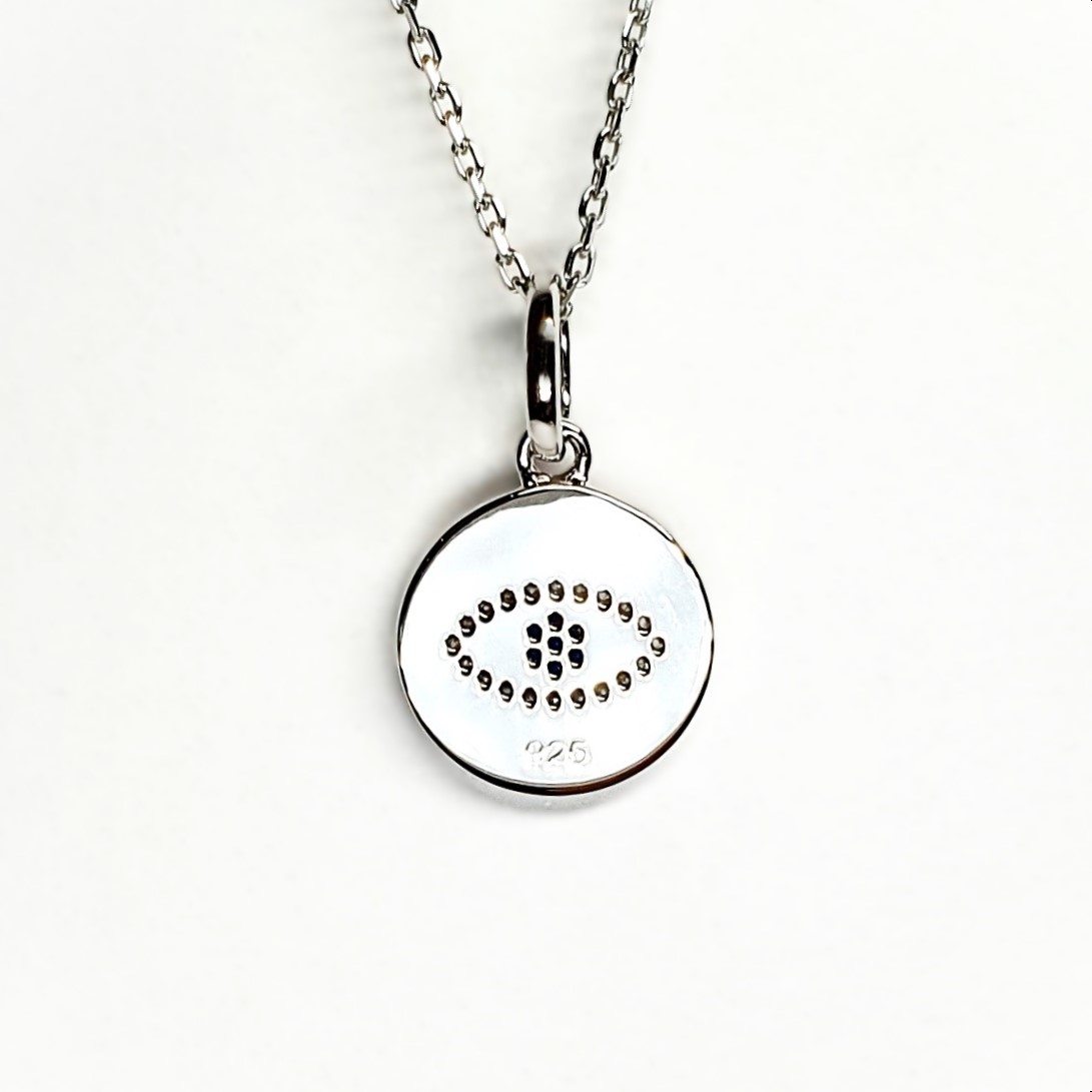 A round disc silver evil eye necklace/pendant made in real sterling silver with sparkling blue & white cubic zirconia with a highly polished finish. Back view.