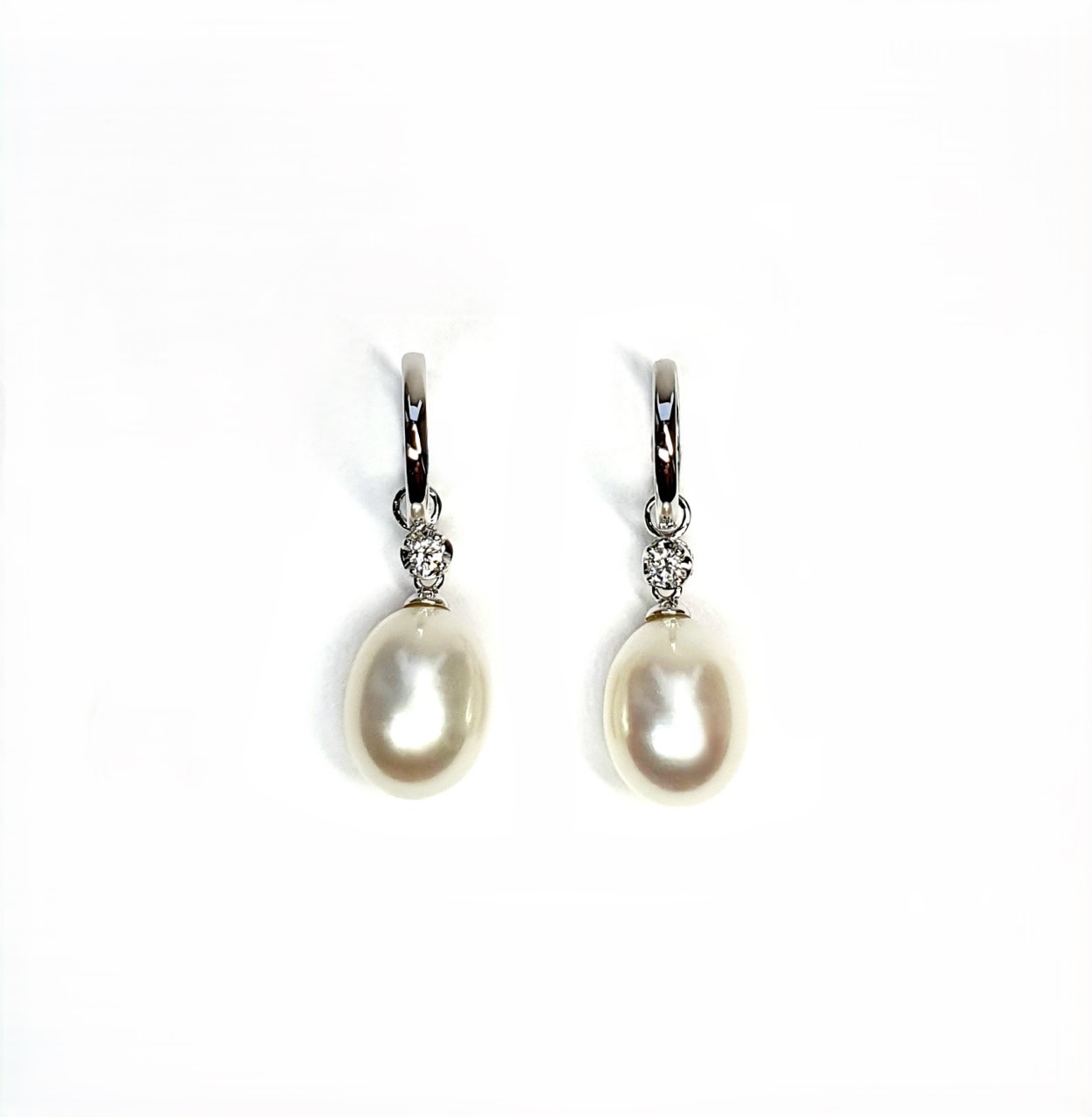 18ct white gold polished huggie loop/hoop earrings leading to a single round diamond and then onto  a single oval pearl drop.