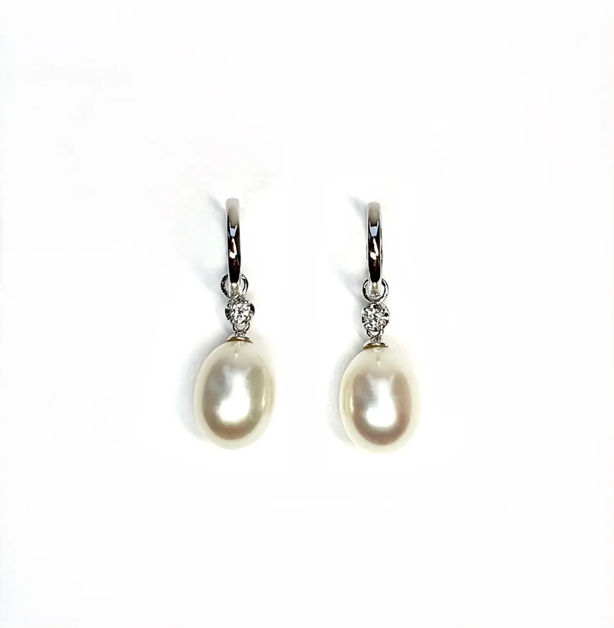 18ct white gold polished huggie loop/hoop earrings leading to a single round diamond and then onto  a single oval pearl drop.