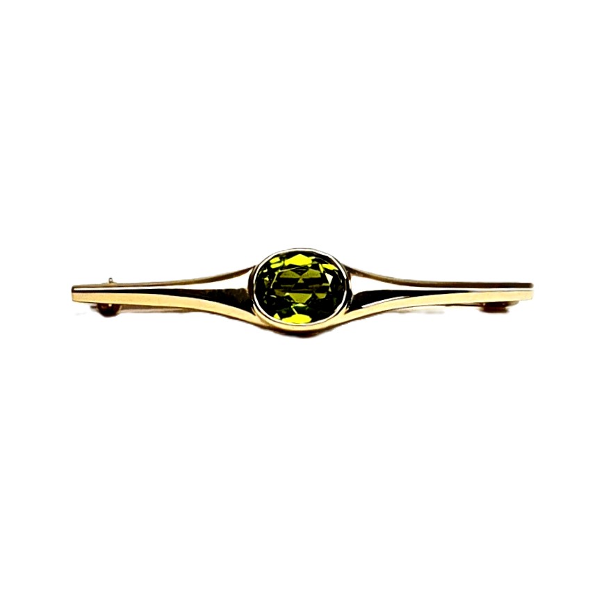 9ct yellow gold pre-loved bar brooch with an oval peridot gemstone in a landscape rub-over setting with a straight pin and a swivel safety catch.