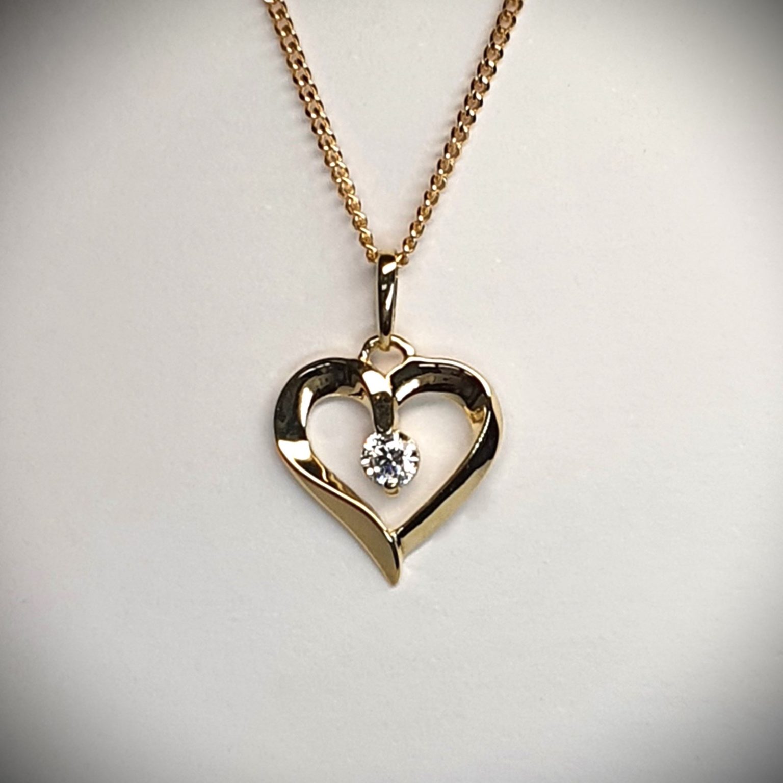 9ct yellow gold open heart pendant and chain necklace with a single 3mm cubic zirconia set to the centre with or without a 16,18, or 20inch 9ct gold curb link chain.