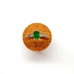 Top view of step cut emerald ring on a cork