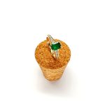 Angled view of emerald ring on textured cork