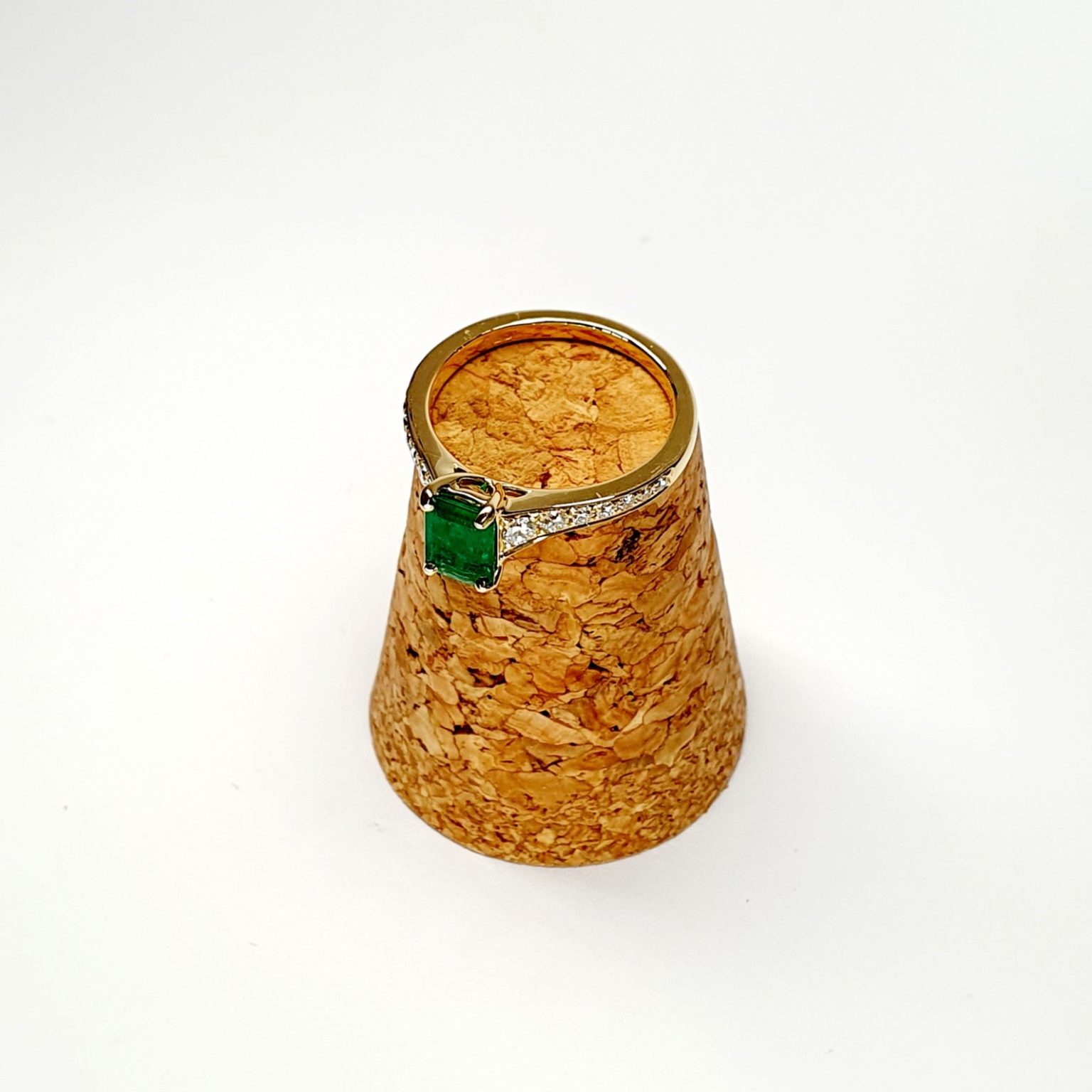 Ring posed diagonally on cork with gemstone facing left