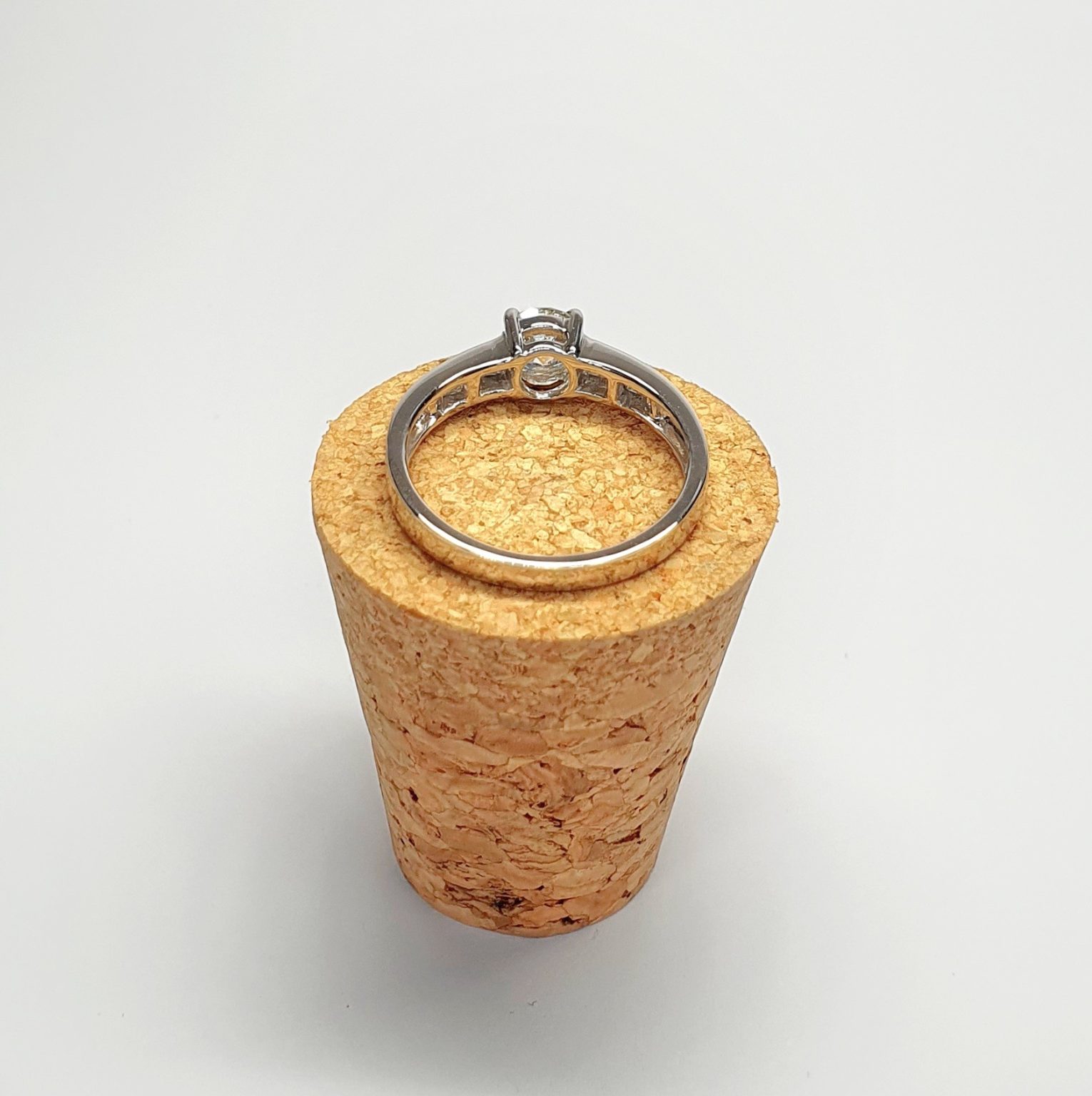 The Lambeth Platinum Diamond Engagement Ring RPT00045 The centre is set with a 0.70ct round brilliant-cut diamond of Colour H clarity SI1, which has an excellent cut, proportions, and symmetry. The side shoulders are channel set with a total of four princess-cut diamonds and four baguette-cut diamonds. The total diamond weight is 1.08 carats.