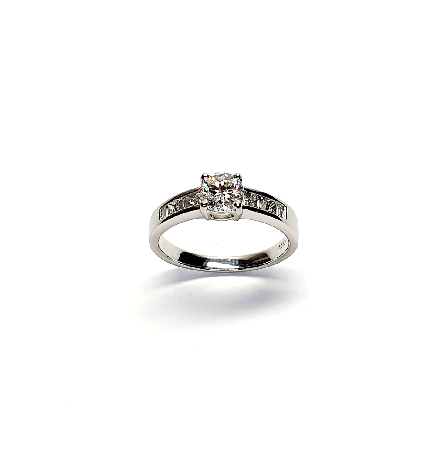 The Lambeth Platinum Diamond Engagement Ring RPT00045 The centre is set with a 0.70ct round brilliant-cut diamond of Colour H clarity SI1, which has an excellent cut, proportions, and symmetry. The side shoulders are channel set with a total of four princess-cut diamonds and four baguette-cut diamonds. The total diamond weight is 1.08 carats.
