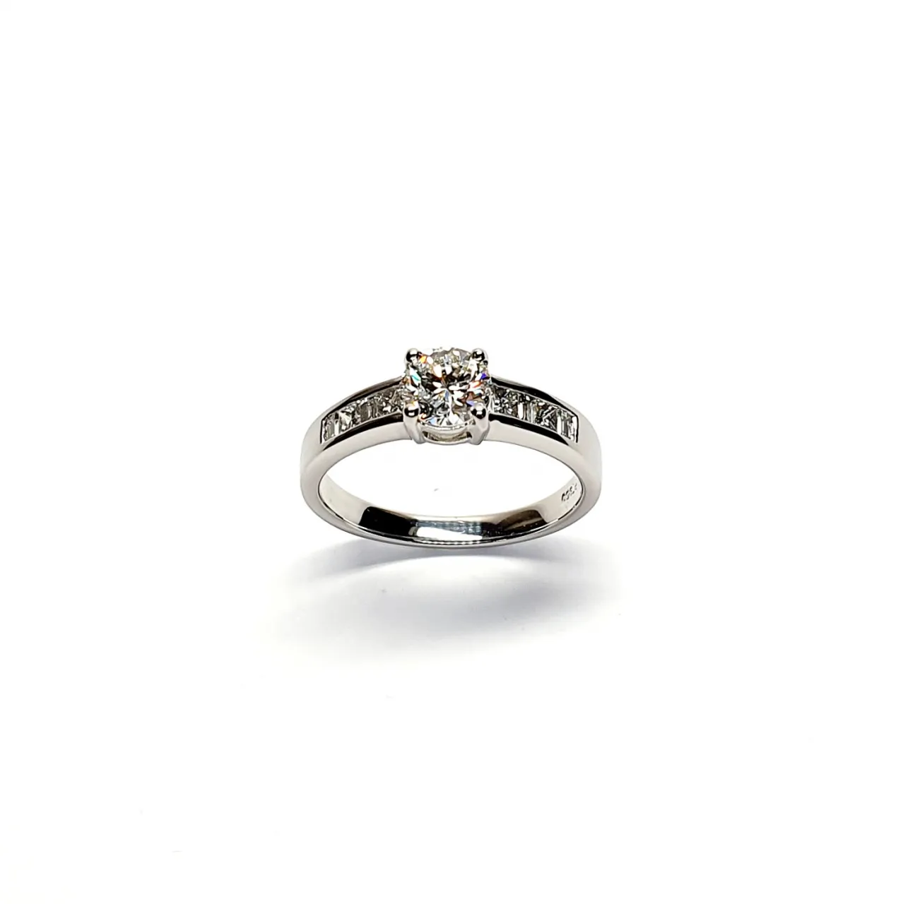 The Lambeth Platinum Diamond Engagement Ring RPT00045 The centre is set with a 0.70ct round brilliant-cut diamond of Colour H clarity SI1, which has an excellent cut, proportions, and symmetry. The side shoulders are channel set with a total of four princess-cut diamonds and four baguette-cut diamonds. The total diamond weight is 1.08 carats.