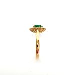 At the heart of this exquisite 18ct yellow gold ring lies a resplendent 7mm x 5mm oval emerald weighing an impressive 0.84 carats and exuding an enchanting green hue. Its captivating charm captures the essence of nature's beauty, with twelve dazzling round brilliant-cut diamonds, totalling 0.41 carats, surrounding the emerald. Each stone is meticulously selected to enhance the ring's allure with unparalleled radiance and brilliance, and the basket-wire setting measures 13mm x 10mm.RA00696.