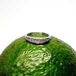 Avocado Elegance: The rich green backdrop of an avocado highlights the brilliance of the nine princess-cut diamonds and the polished 18ct white gold, creating a stunning visual contrast.