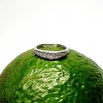 Avocado Elegance: The rich green backdrop of an avocado highlights the brilliance of the nine princess-cut diamonds and the polished 18ct white gold, creating a stunning visual contrast.