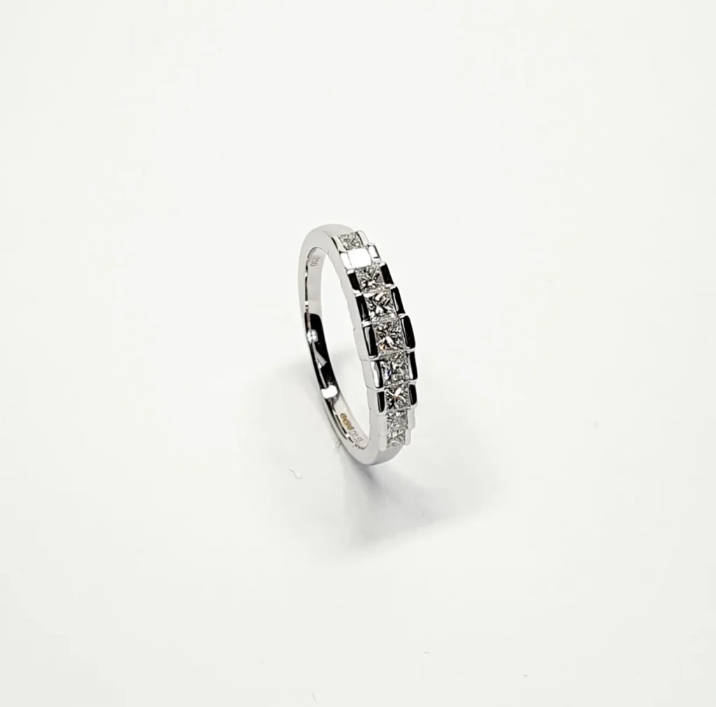 Art Deco style eternity ring crafted in 18ct white gold & set with nine graduated square princess cut diamonds in graduating square box style settings RA00697.