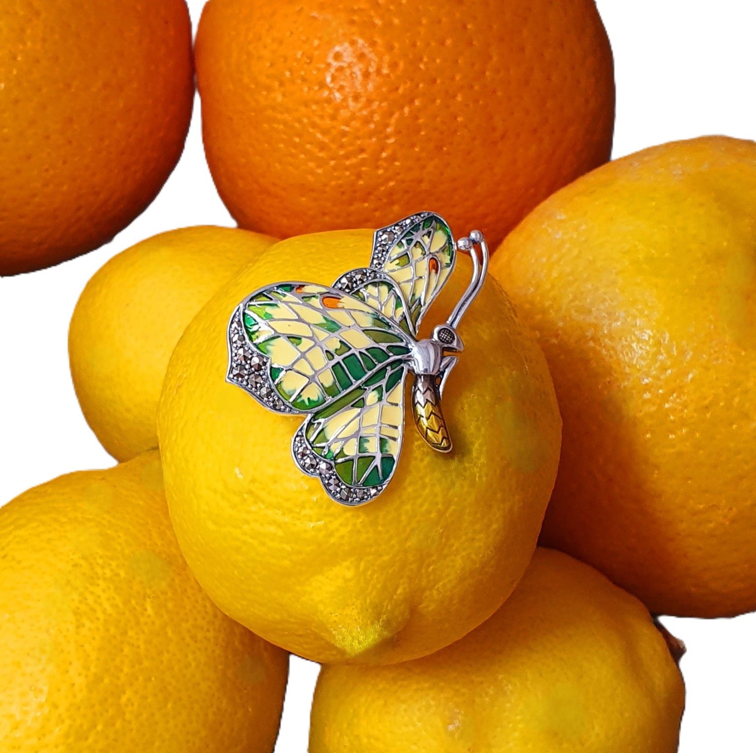 Lemon Butterfly Brooch Sterling Silver BRS00107 Genuine 925 sterling silver butterfly brooch with lemon and pale green colour Plique-à-jour enamel wings with real marcasite set to the tips, the body and eye with a golden yellow enamel with two long polished silver antennae.