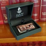 Douglas Pell cash clip Pictured in the box on a bookshelf.