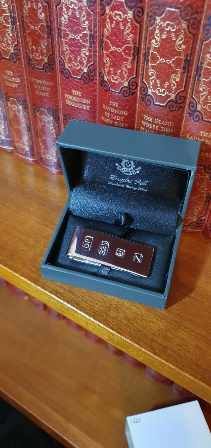 Douglas Pell clip for your cash Pictured in the box on a bookshelf.