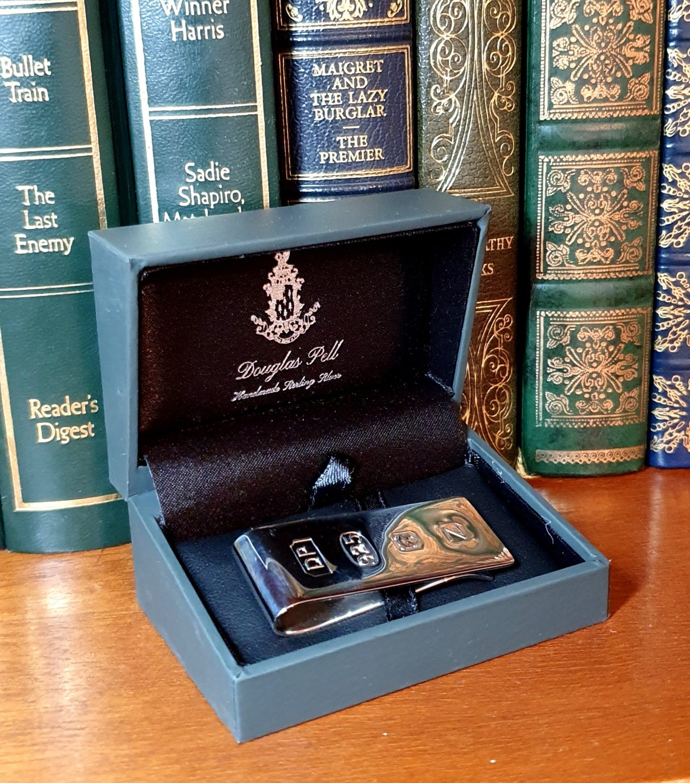 Money Clip (50mm x 18mm) has large feature hallmarks, similar to those used in a James Bond film. (Stock number MC0034) It is Picture on a red book