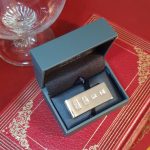 A large feature hallmarked silver money clip (Stock number MC0034). It is Pictured in a box on a red book.