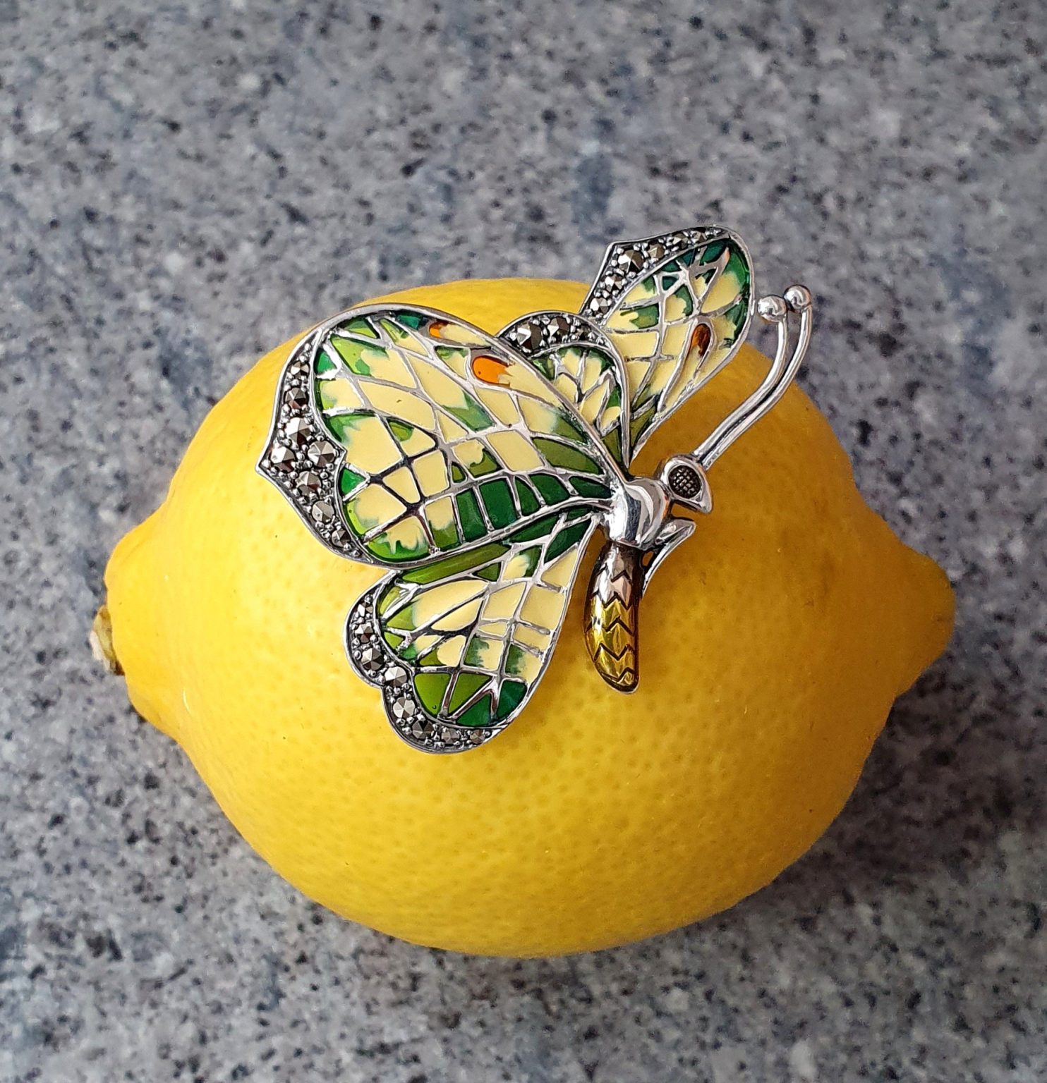 Lemon Butterfly Brooch Sterling Silver BRS00107 Genuine 925 sterling silver butterfly brooch with lemon and pale green colour Plique-à-jour enamel wings with real marcasite set to the tips, the body and eye with a golden yellow enamel with two long polished silver antennae.
