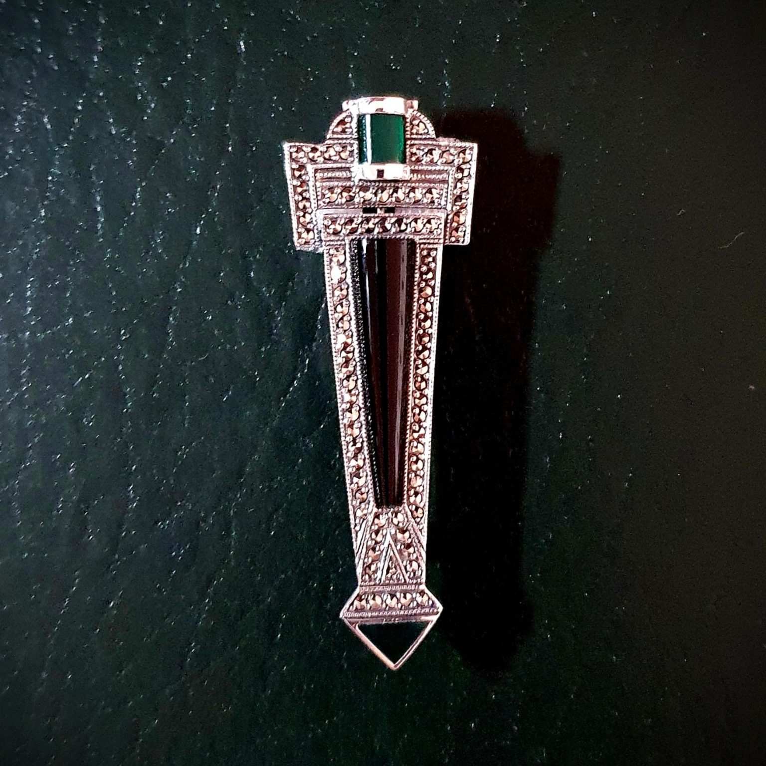 Art Deco style Brooch pin set with Black Onyx, Green Agate and Marcasite BRS00106. Front view on dark green background.