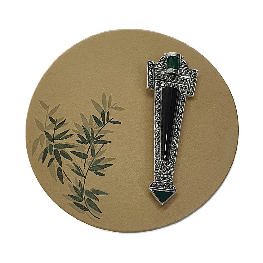 Art Deco-style Brooch pin set with Black Onyx, Green Agate, and marcasite BRS00106. Front view on beige. circle with green leaf's to the left side. green leaf