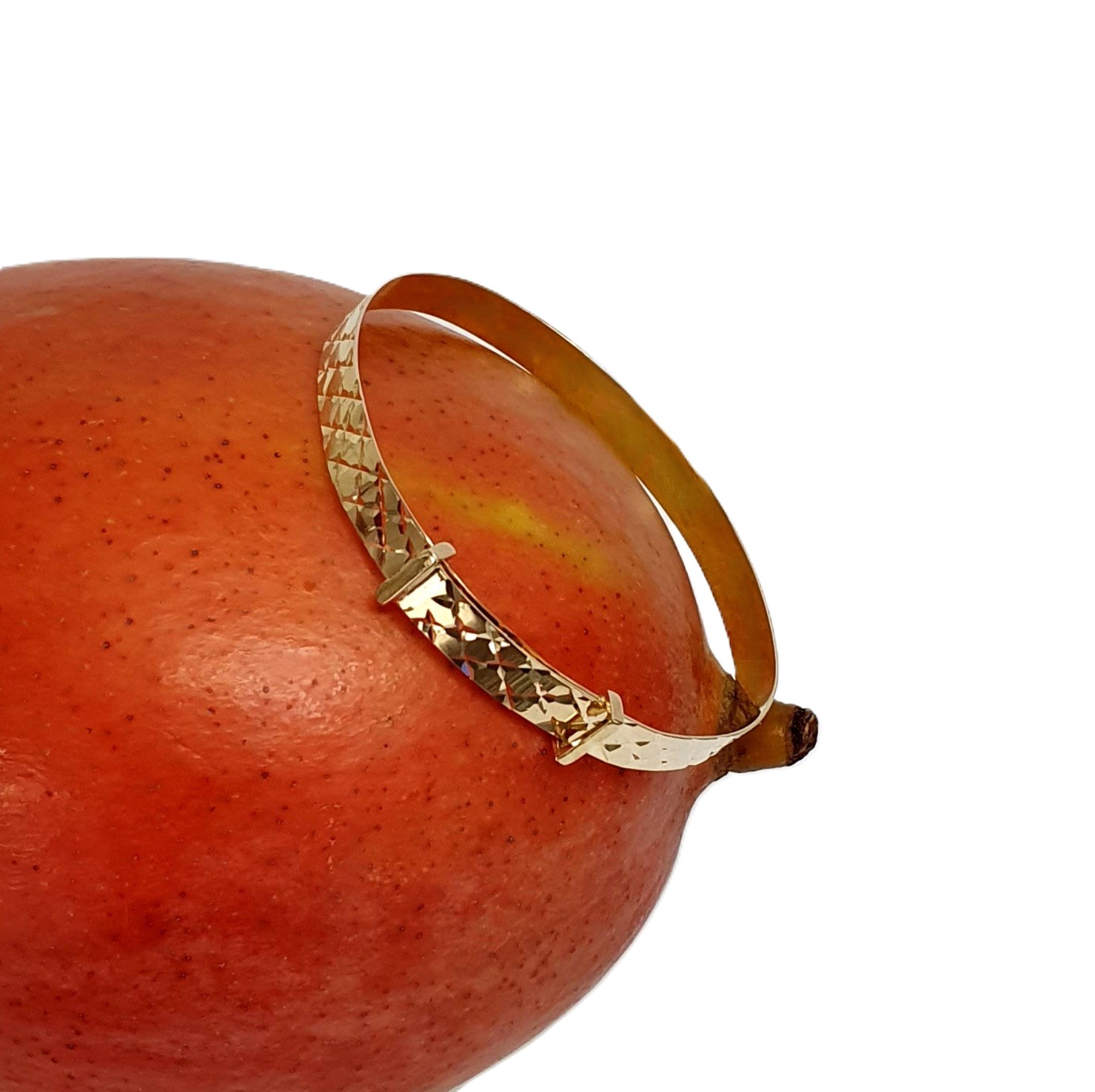 Baby bangle shown laying on one side of a mango