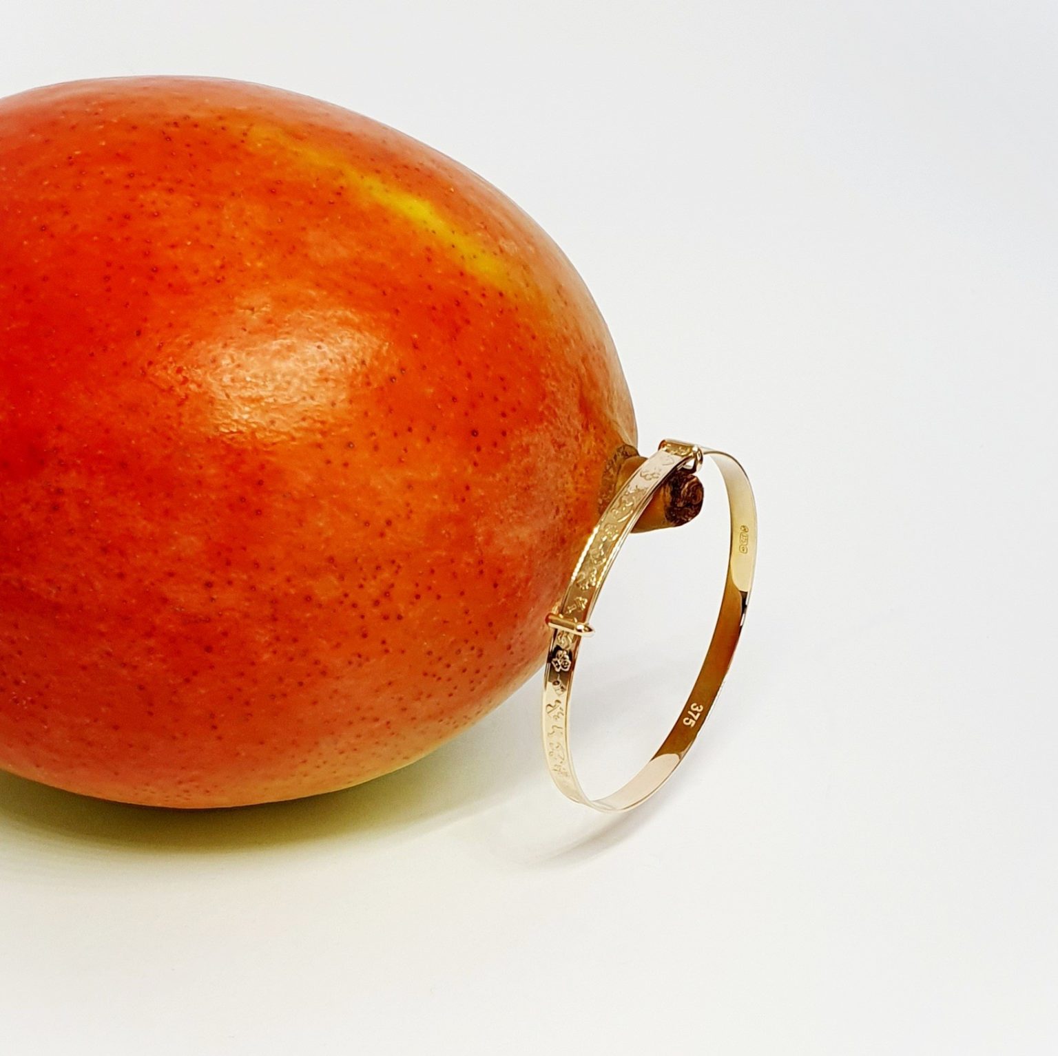 Yellow gold small adjustable Bath baby bangle bracelet with embossed pictures of toys.