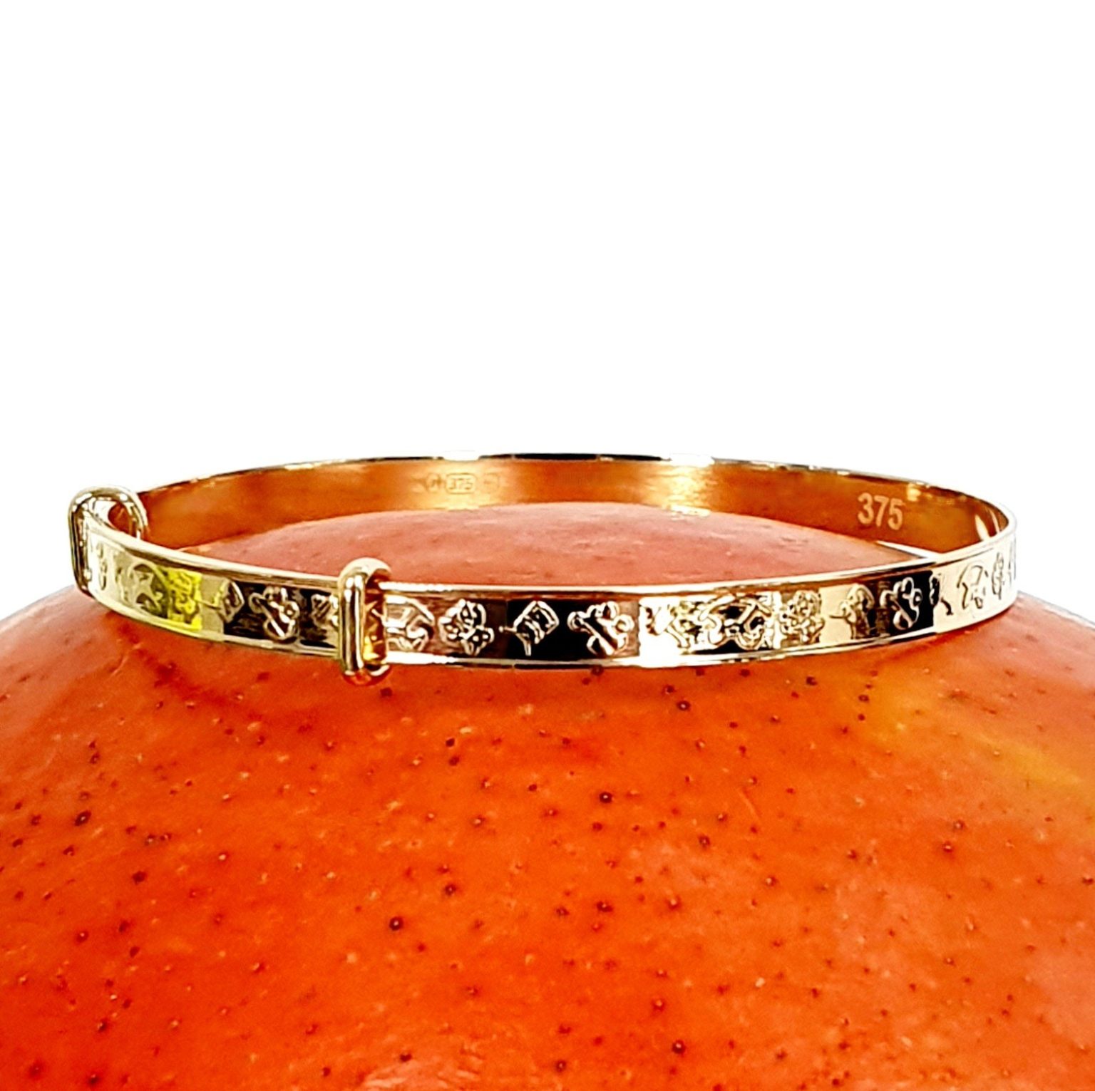 Yellow gold small adjustable Bath baby bangle bracelet with embossed pictures of toys.