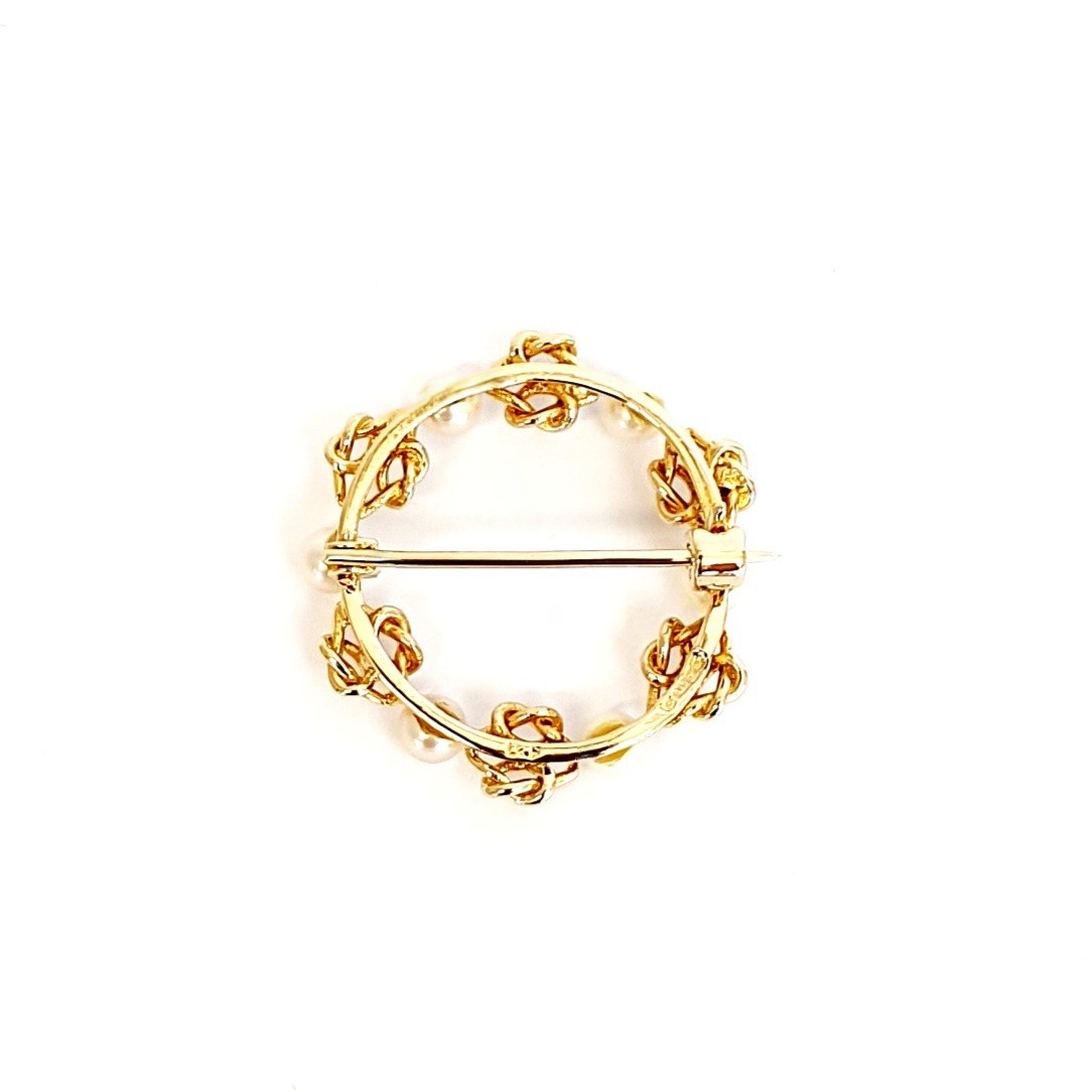 A 9ct yellow gold circle brooch of six 3.8mm pearls & six gold double knots alternately equally spaced in a circle, picture shows back view.