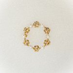 A 9ct yellow gold circle brooch of six 3.8mm pearls & six gold double knots alternately equally spaced in a circle, picture shows front view.