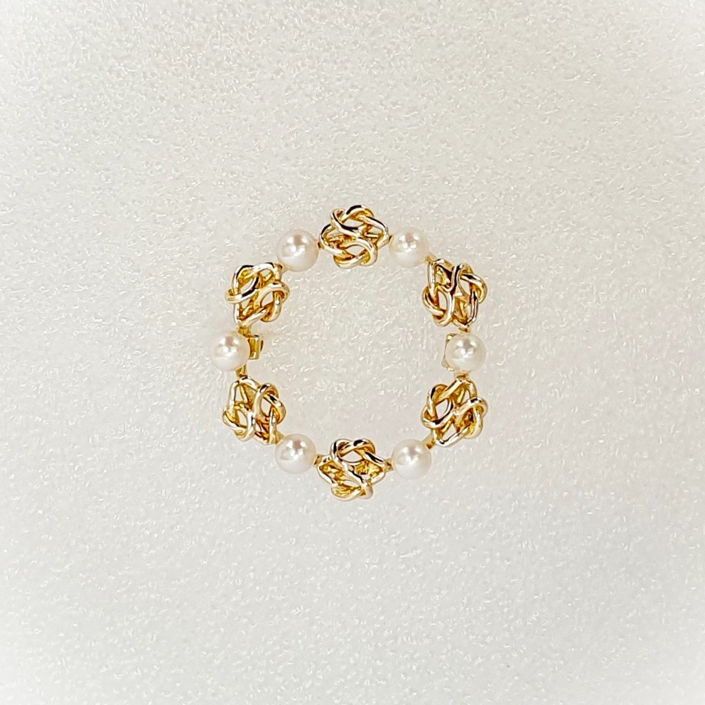 A 9ct yellow gold circle brooch of six 3.8mm pearls & six gold double knots alternately equally spaced in a circle, picture shows front view.