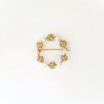 A 9ct yellow gold circle brooch of six 3.8mm pearls & six gold double knots alternately equally spaced in a circle, picture shows front view.