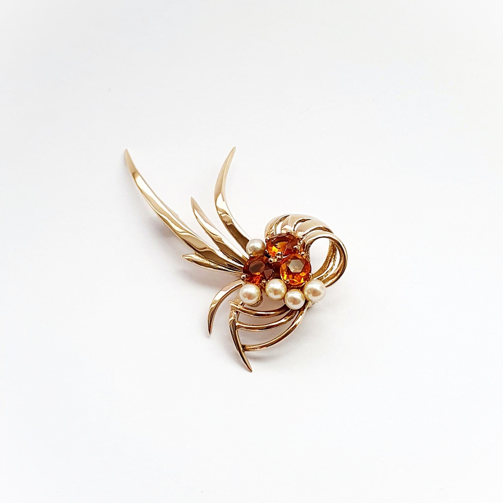 This gorgeous multi-loop bow brooch is crafted in 9ct yellow gold and features three golden yellow Citrines and five white pearls.