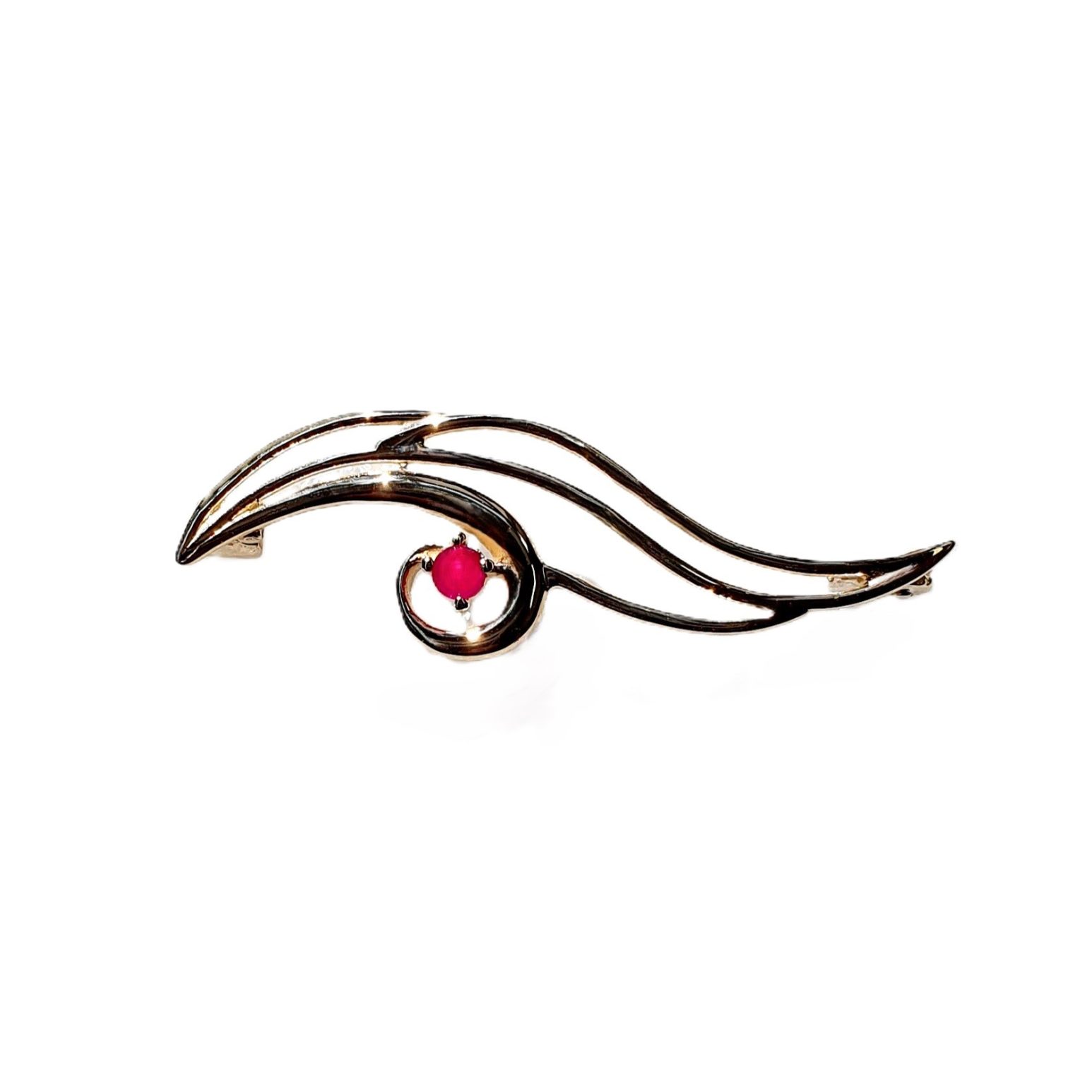 This unusual brooch is crafted in 9ct yellow gold in the shape of the eye of Horus with a single red ruby iris. Front view.