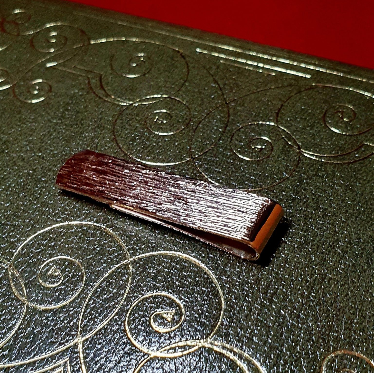 Gold clip for your notes with a unique tree bark pattern, ideal as a gift pictured on a twenty-pound note.