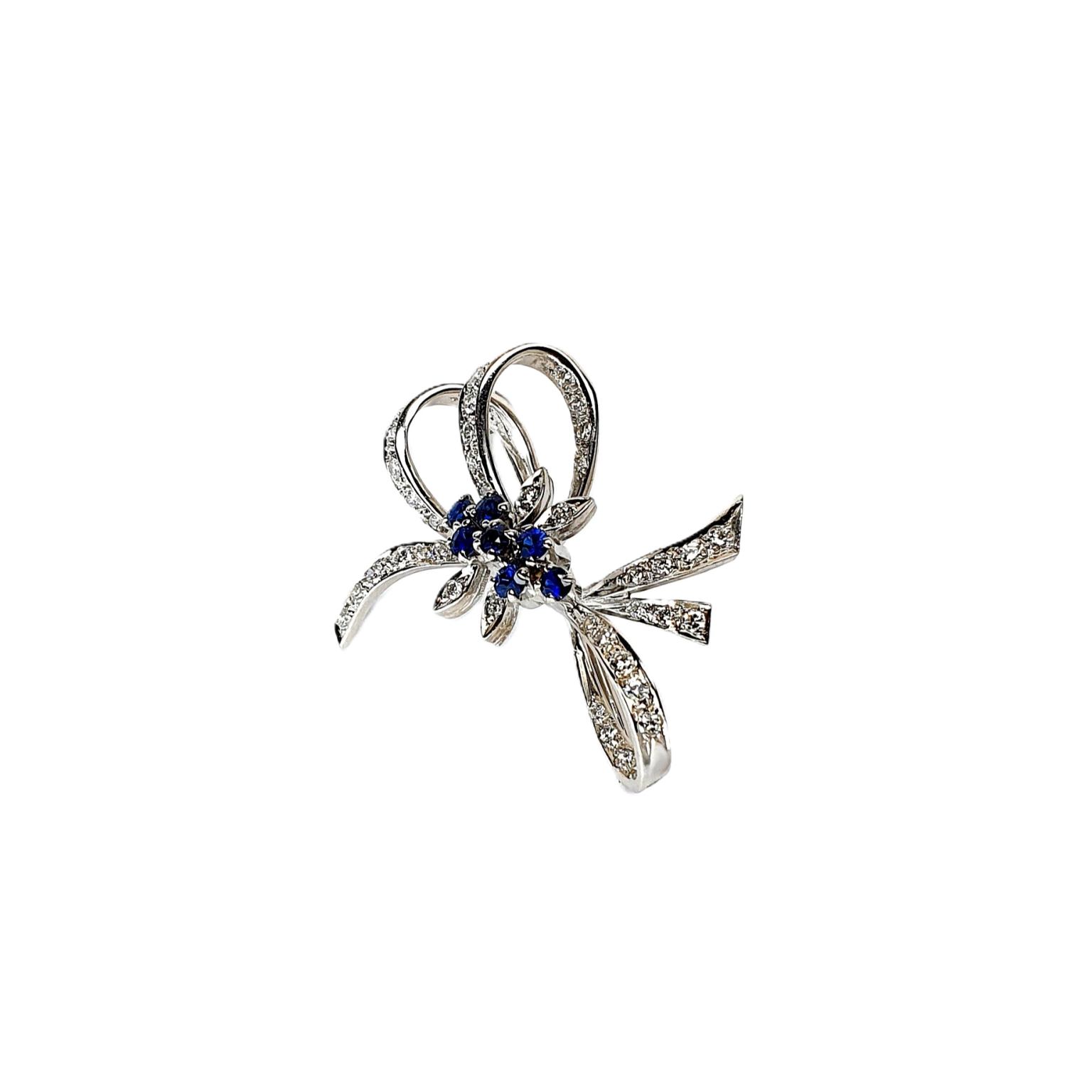 Angled View "An angled shot of the Cropp & Farr brooch, capturing the sparkling sapphires and diamonds, and the graceful curves of the bow design. Stock number: BRQ00050."