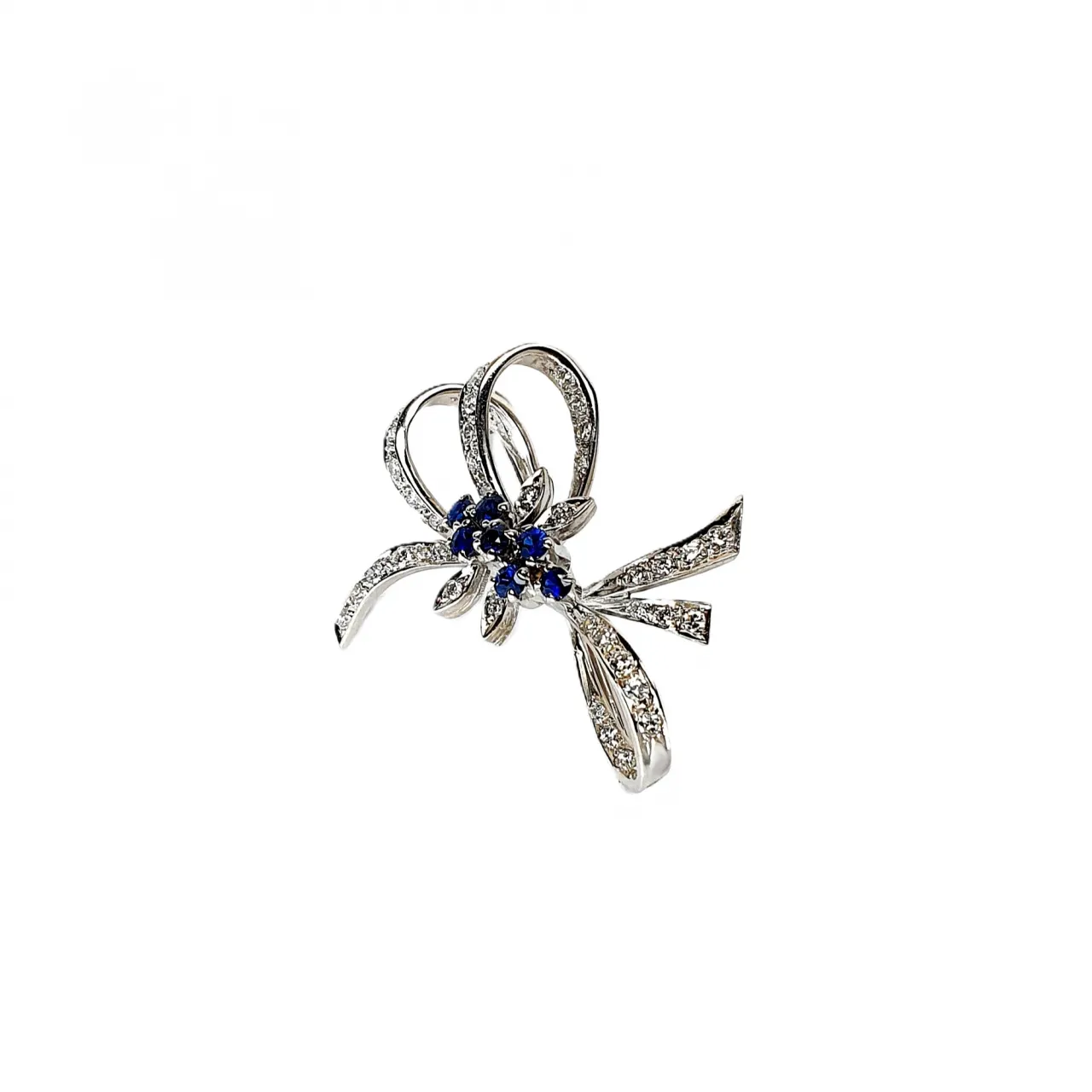 Angled View "An angled shot of the Cropp & Farr brooch, capturing the sparkling sapphires and diamonds, and the graceful curves of the bow design. Stock number: BRQ00050."