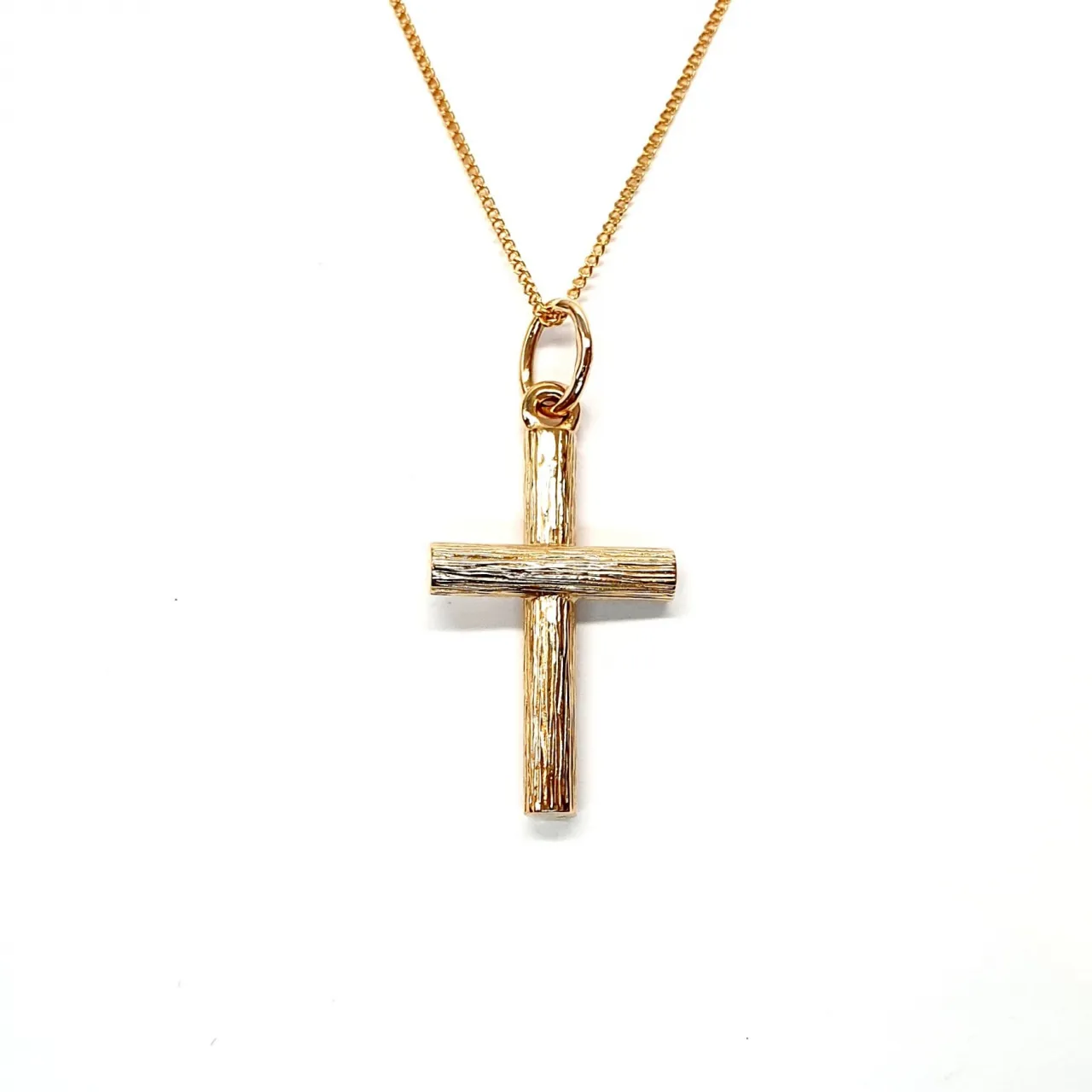 9ct gold cross pendant with hand-engraved tree bark texture.
