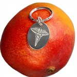 Oval medical alert key ring fob in real silver pictured on a mango.