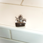 fairy tail pill box in solid silver sitting on a wall.