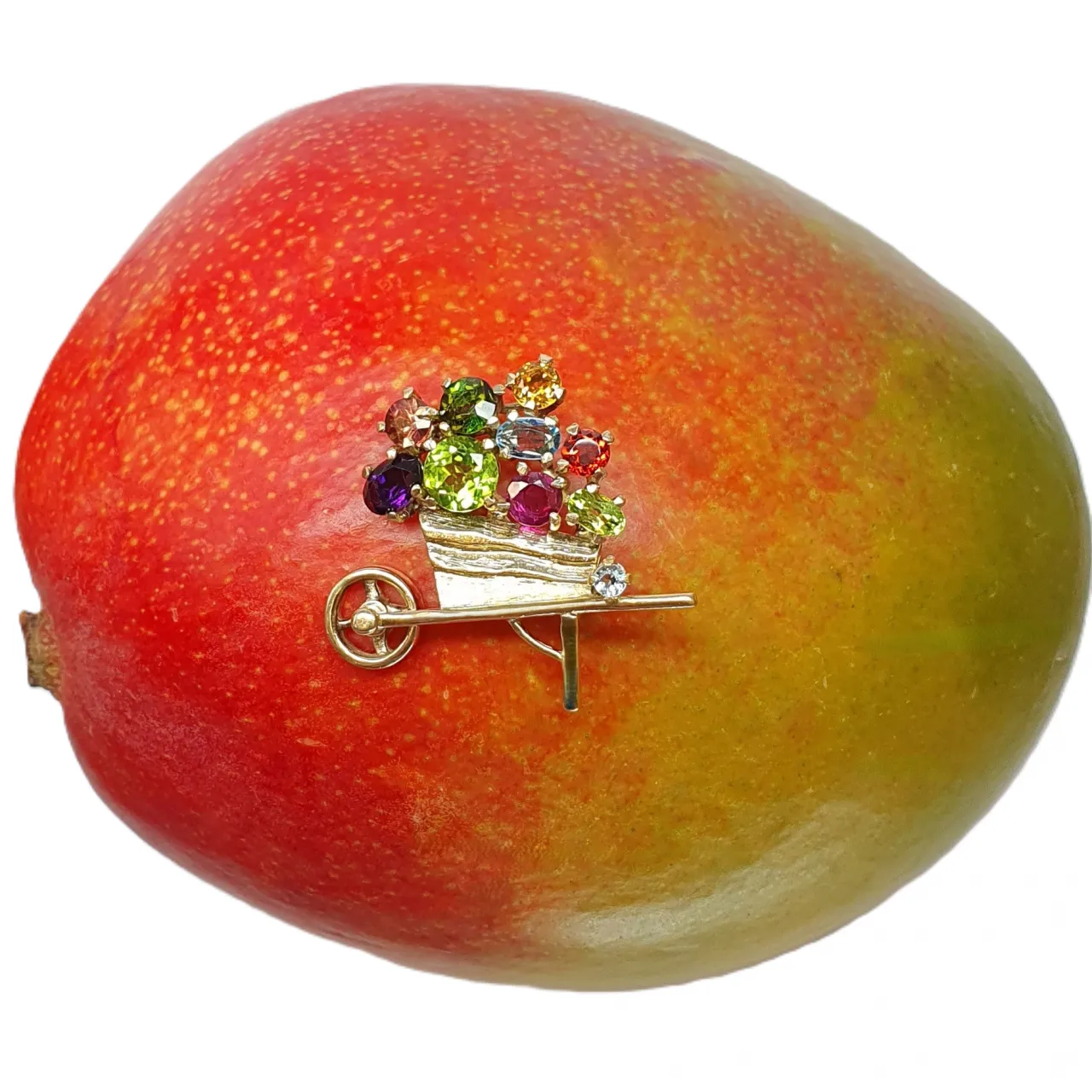 Front View 1: This is an image of the front of the 9ct Gold Gemstone Wheel Bow Brooch pictured on a mango. It displays the amethyst, blue topaz, citrine, garnet, peridot, and tourmaline set in yellow gold.