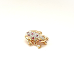 Frog brooch shown from an angle with ruby eye facing.