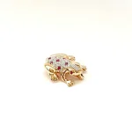 Frog brooch shown from an angle with ruby eye facing.