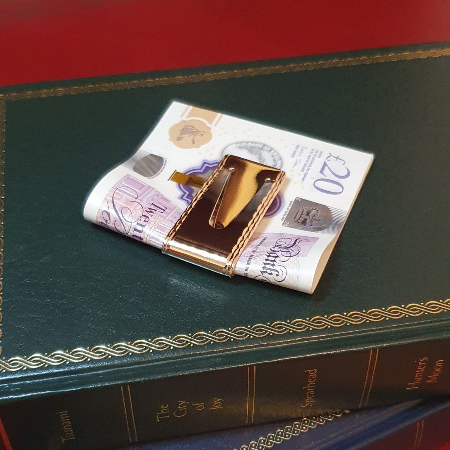 A luxurious hallmarked pound note holder pictured with twenty-pound notes.