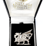 Crafted from premium silver, this exquisite dragon brooch symbolizes strength and pride, making it an elegant gift. Pictured in a black velvet box.