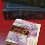 A luxurious hallmarked money holder is pictured with twenty-pound notes.