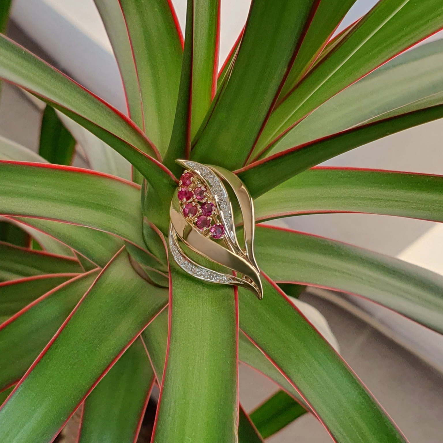 Ruby brooch pin pictured on a plant.