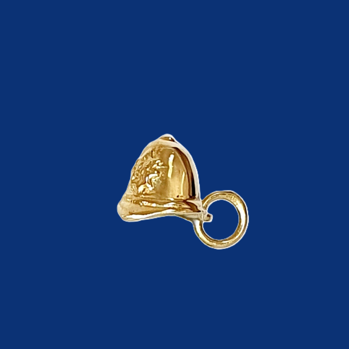 9-carat gold charm featuring a detailed police helmet. pictured on a blue back ground.